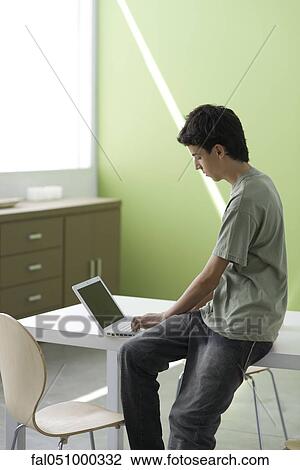 Teenage boy using laptop computer View Large Photo Image Stock Image - Teenage boy using laptop computer. Fotosearch