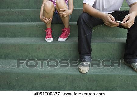 Teenage couple sitting together on steps View Large Photo Image Stock Photo - Teenage couple sitting together on steps. Fotosearch