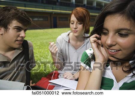 Teenage friends hanging out, girls sharing earphones, listening to music View Large Photo Image Stock Image - Teenage friends hanging out, girls sharing earphones, listening to music. Fotosearch