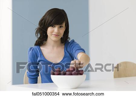 Picture - Teenage girl eating grapes. Fotosearch