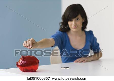 Teenage girl putting coin in piggy bank View Large Photo Image Stock Photo - Teenage girl putting coin in piggy bank. Fotosearch