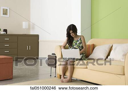 Teenage girl using laptop in living room View Large Photo Image Stock Photograph - Teenage girl using laptop in living room. Fotosearch