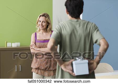 Teenage son preparing to present gift to mother View Large Photo Image Stock Image - Teenage son preparing to present gift to mother. Fotosearch