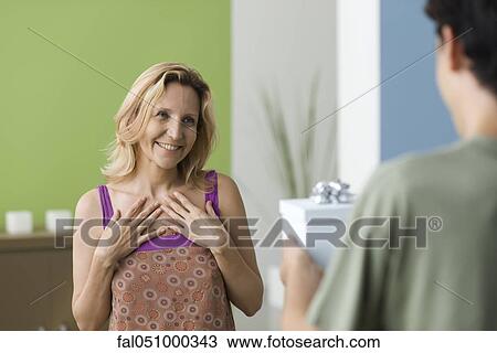 Teenage son presenting gift to mother View Large Photo Image Stock Image - Teenage son presenting gift to mother. Fotosearch