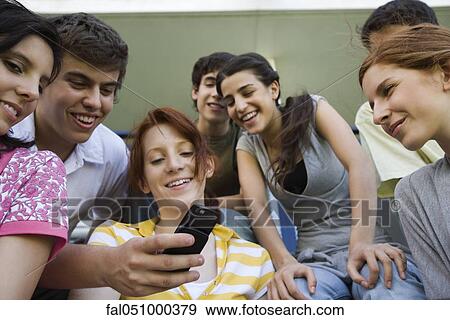Teenagers looking at friend's photophone View Large Photo Image Stock Photo - Teenagers looking at friend's photophone. Fotosearch