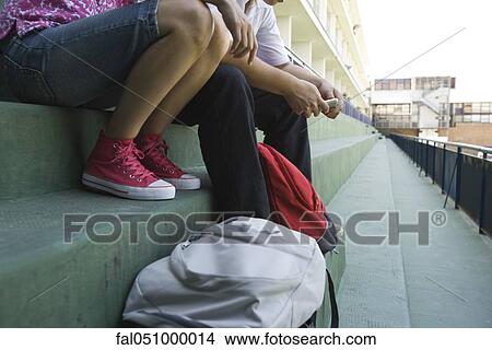 Teenagers sitting together on steps, low section View Large Photo Image Picture - Teenagers sitting together on steps, low section. Fotosearch