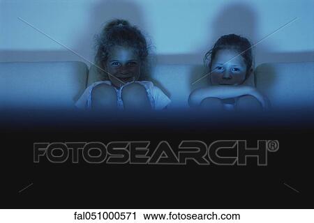 Two girls watching TV together at night View Large Photo Image Stock Image - Two girls watching TV together at night. Fotosearch