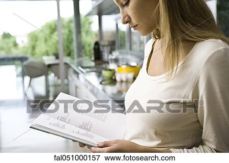 Woman reading recipe in cookbook View Large Photo Image Stock Photo - Woman reading recipe in cookbook. Fotosearch