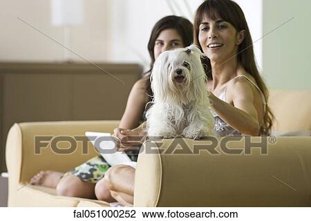 Stock Image - Woman relaxing with pet dog and teenage daughter. Fotosearch