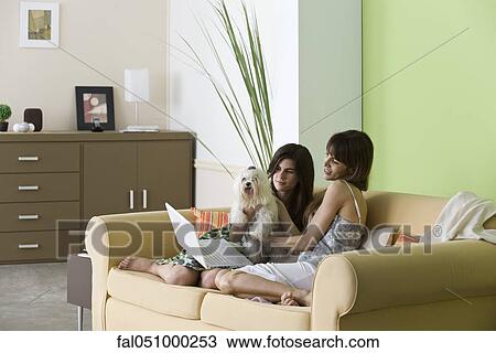 Stock Image - Woman relaxing with pet dog and teenage daughter. Fotosearch
