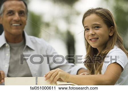 Stock Image - Young girl building box with father. Fotosearch