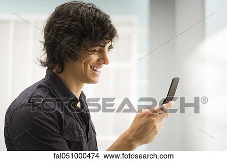 Young man text messaging View Large Photo Image Picture - Young man text messaging. Fotosearch
