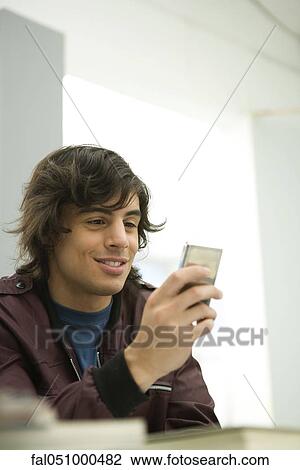 Young man text messaging View Large Photo Image Stock Image - Young man text messaging. Fotosearch