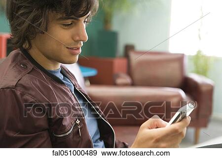 Young man text messaging View Large Photo Image Stock Photo - Young man text messaging. Fotosearch