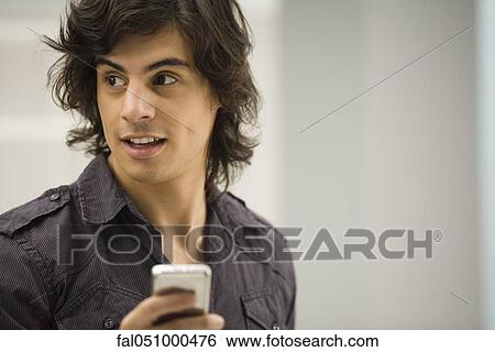 Young man text messaging View Large Photo Image Stock Photograph - Young man text messaging. Fotosearch