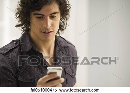 Stock Photography - Young man text messaging. Fotosearch