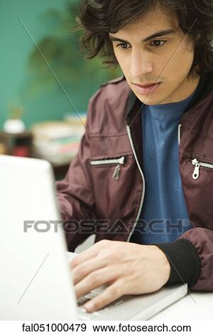 Stock Photo - Young man using laptop. Fotosearch