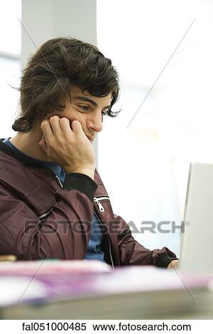 Young man using laptop View Large Photo Image Stock Photography - Young man using laptop. Fotosearch