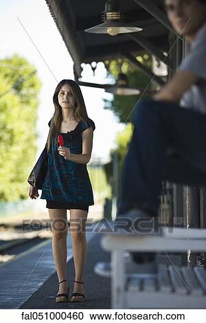 Young woman with popsicle waiting at bus stop View Large Photo Image Stock Image - Young woman with popsicle waiting at bus stop. Fotosearch