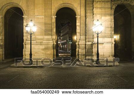 Stock Photo - Arcade illuminated by street lamps, The Louvre, Paris, France. Fotosearch