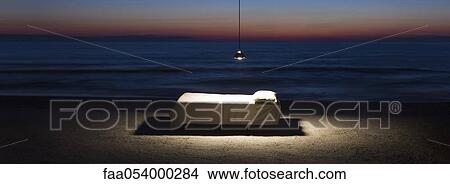 Bed illuminated by hanging lamp on beach View Large Photo Image Picture - Bed illuminated by hanging lamp on beach. Fotosearch