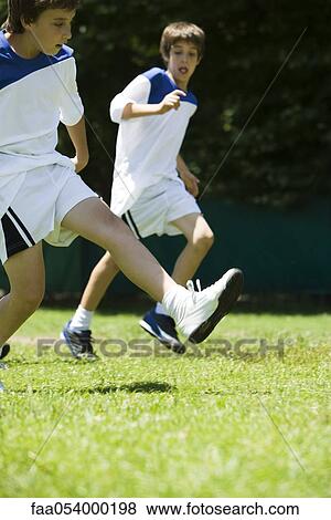 Stock Photo - Boys running on soccer field. Fotosearch