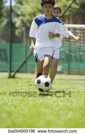 Stock Photograph - Children playing soccer, cropped. Fotosearch