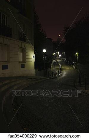 Stock Photo - Cobblestone street at night, Montmartre, Paris, France. Fotosearch