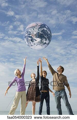 Stock Image - Ecology concept, group of people saving the earth together. Fotosearch