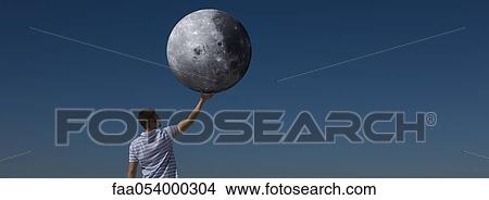Picture - Ecology concept, man holding the moon. Fotosearch