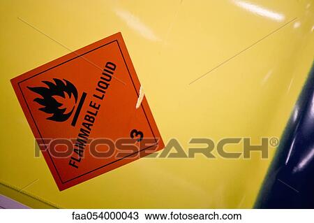 Stock Image - Fabric coating plant, flammable warning label on side of metal drum. Fotosearch