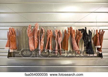 Stock Photography - Fabric coating plant, rubber gloves drying on rack. Fotosearch
