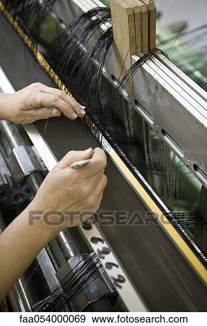 Stock Photo - Fabric coating plant, weaving department, mechanist preparing weaver's reed on loom. Fotosearch