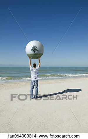 Holding aloft globe displaying image of trees View Large Photo Image Picture - Holding aloft globe displaying image of trees. Fotosearch