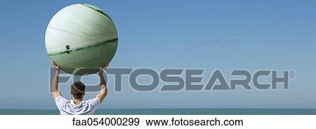 Holding aloft globe displaying image of cultivated agricultural fields View Large Photo Image Stock Photo - Holding aloft globe displaying image of cultivated agricultural fields. Fotosearch