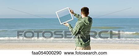 Holding framed picture of ocean at angle against ocean in background View Large Photo Image Stock Image - Holding framed picture of ocean at angle against ocean in background. Fotosearch