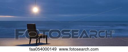 Light bulb illuminated over chair on beach at night View Large Photo Image Stock Photo - Light bulb illuminated over chair on beach at night. Fotosearch