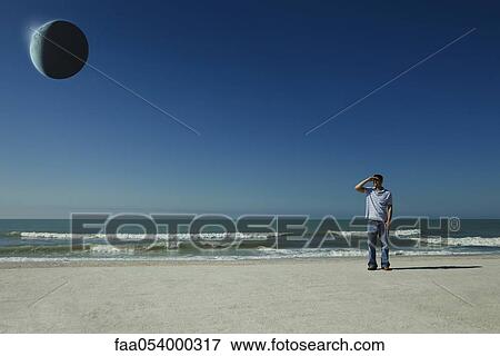 Man on beach observing eclipse View Large Photo Image Stock Photo - Man on beach observing eclipse. Fotosearch