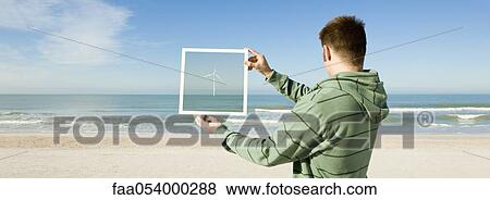 Offshore wind turbine on horizon viewed from beach View Large Photo Image Stock Photo - Offshore wind turbine on horizon viewed from beach. Fotosearch