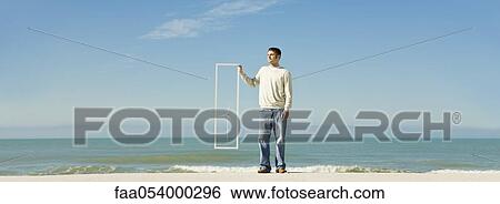 Stock Photograph - Offshore wind turbine on horizon viewed from beach. Fotosearch