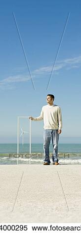 Stock Photography - Offshore wind turbine on horizon viewed from beach. Fotosearch