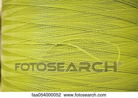 Stock Image - Recyclable composite textile fabrication department of factory, reel of coated thread. Fotosearch
