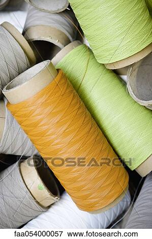 Stock Photo - Recyclable composite textile fabrication department of factory, reels of excess coated thread. Fotosearch