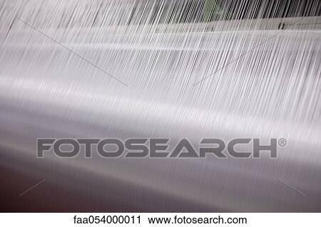 Stock Image - Weaving mill, lap of threads on loom. Fotosearch