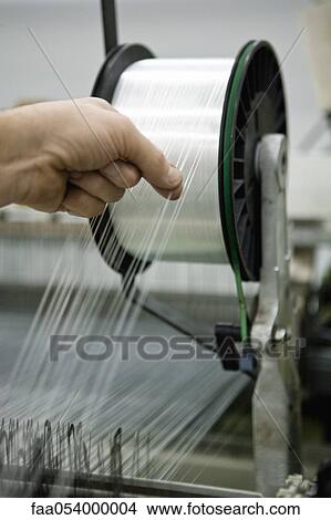 Weaving mill, machinist manually checking thread tension View Large Photo Image Picture - Weaving mill, machinist manually checking thread tension. Fotosearch