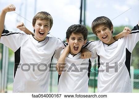 Young soccer teammates with arms raised in victory, portrait View Large Photo Image Stock Photo - Young soccer teammates with arms raised in victory, portrait. Fotosearch