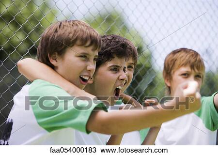 Stock Image - Young teammates cheering from sidelines. Fotosearch