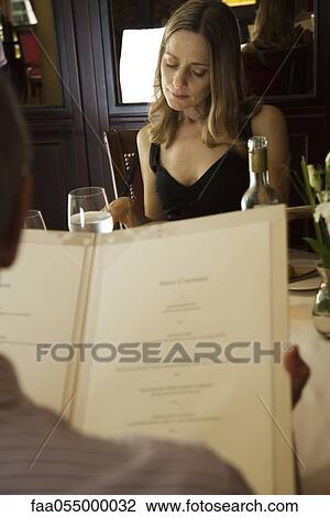 Stock Image - Couple reading menus in restaurant. Fotosearch