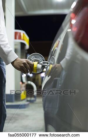 Driver opening gas tank to refuel at gas station View Large Photo Image Stock Photo - Driver opening gas tank to refuel at gas station. Fotosearch