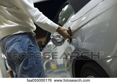 Stock Photograph - Driver opening gas tank to refuel at gas station. Fotosearch